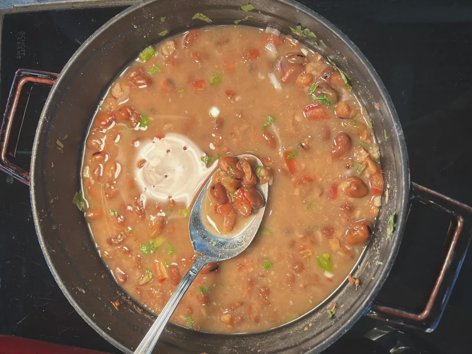 Ful Medames by Mr. Wanderer Skillet of Ful Medames with a spoon showing the bean, overhead shot.