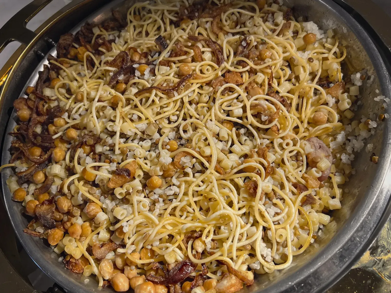 Koshari by Mr. Wanderer Close up overhead shot of serving tray of Koshari.