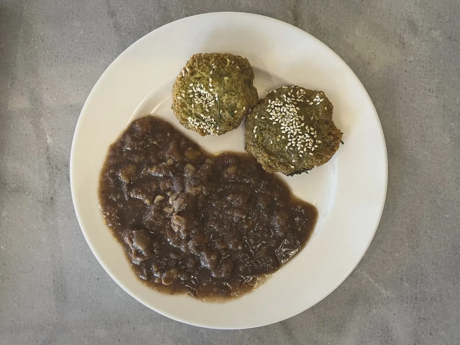 Ta'ameya Breakfast by Mr. Wanderer Two Ta'ameya on a plate with ful medames, overhead shot.