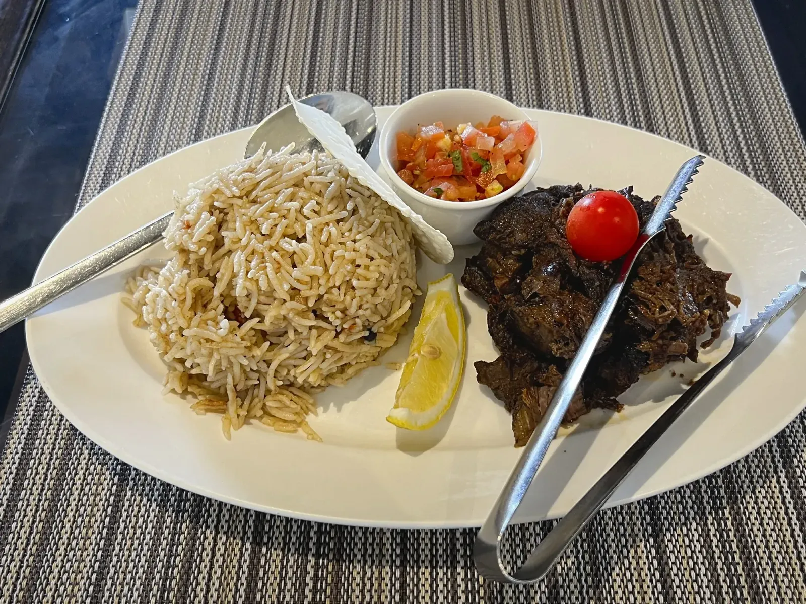 Shuwa by Mr. Wanderer Plate of shuwa with side of rice, angled shot.