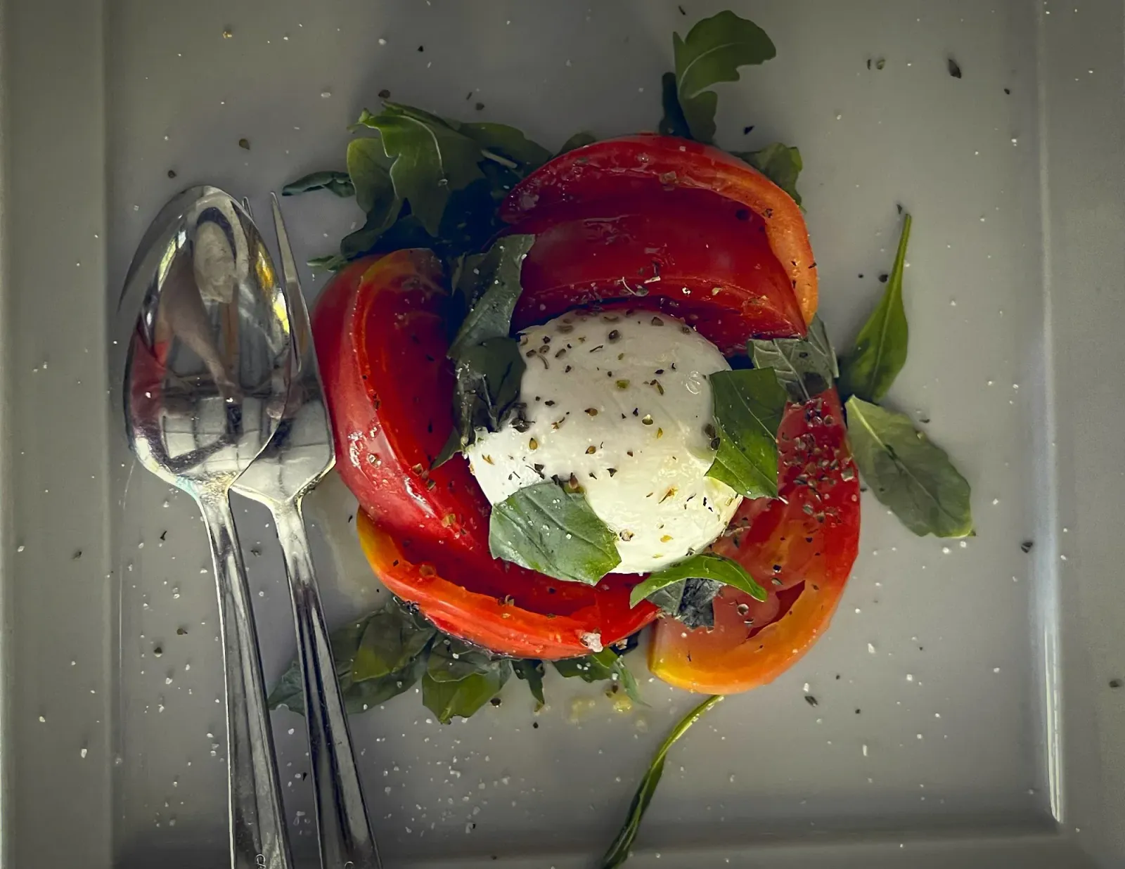 Caprese by Mr. Wanderer Caprese Salad. Overhead shot next to spoon and fork.