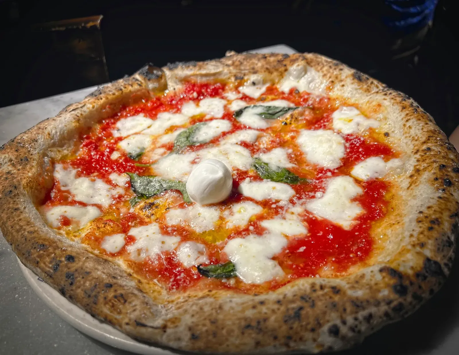 Neapolitan Pizza by Mr. Wanderer Neapolitan pizza. Low angle of a margherita pizza with a ball of mozzarella in the middle.