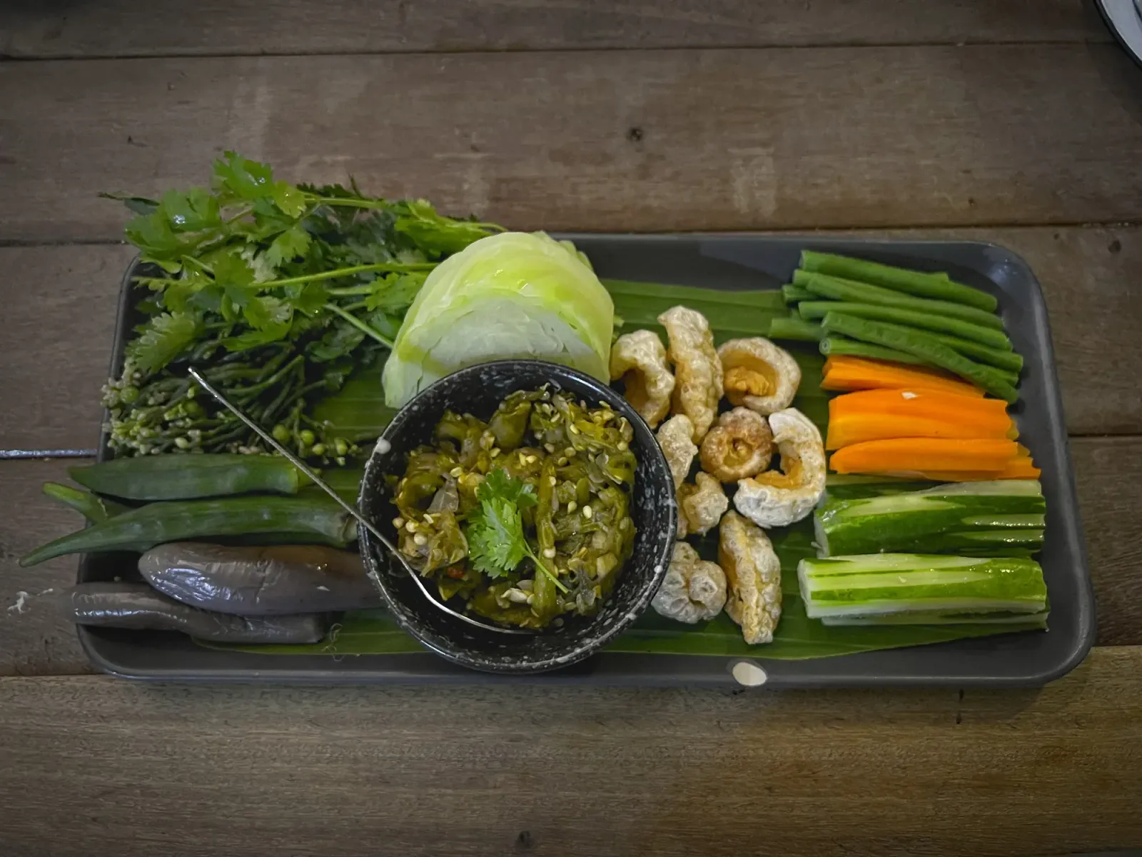 Nam Prik Noom Kab Moo by Mr. Wanderer Overhead shot of a platter of vegetables with a dipping bowl of Nam Prik Noom Kab Moo.