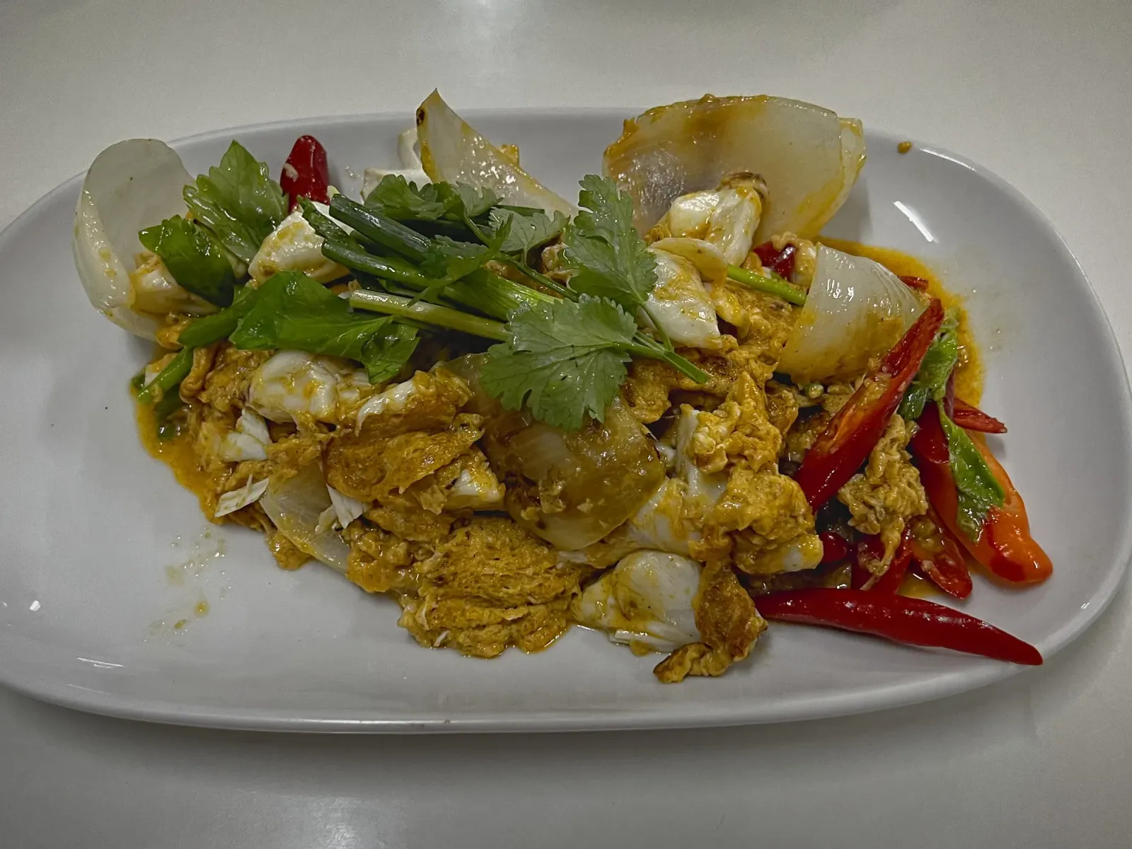Poo Phad Phong Karee by Mr. Wanderer Poo Phad Phong Karee on a serving platter, angled shot.