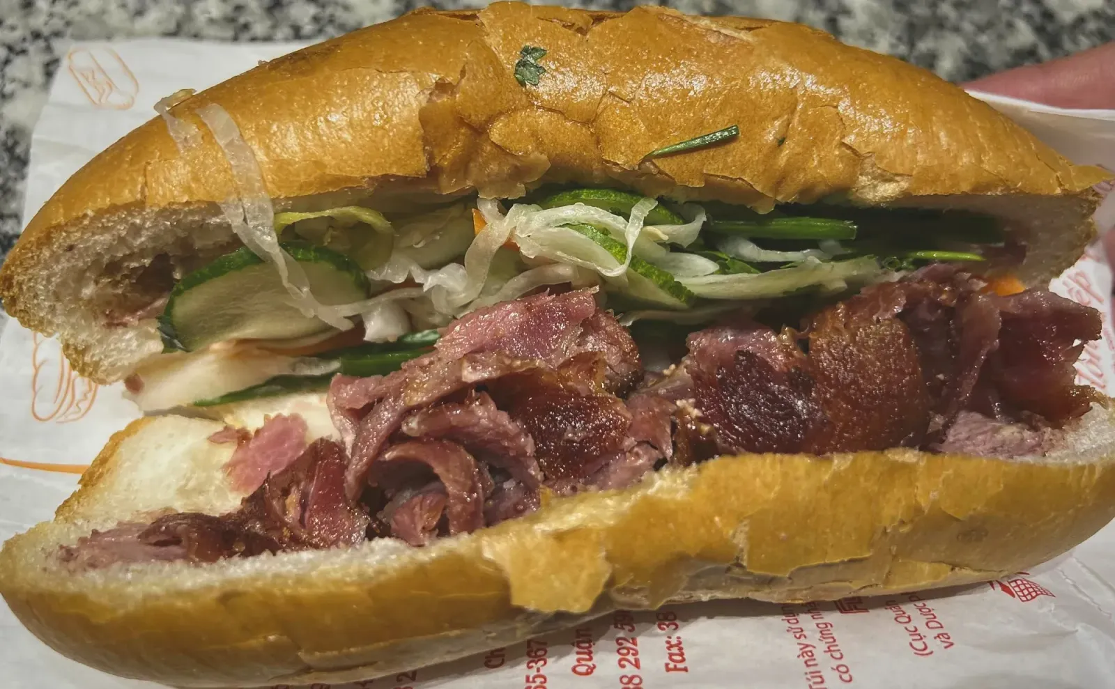 Banh Mi by Mr. Wanderer Banh Mi sandwich, opened slightly, shot from the side.