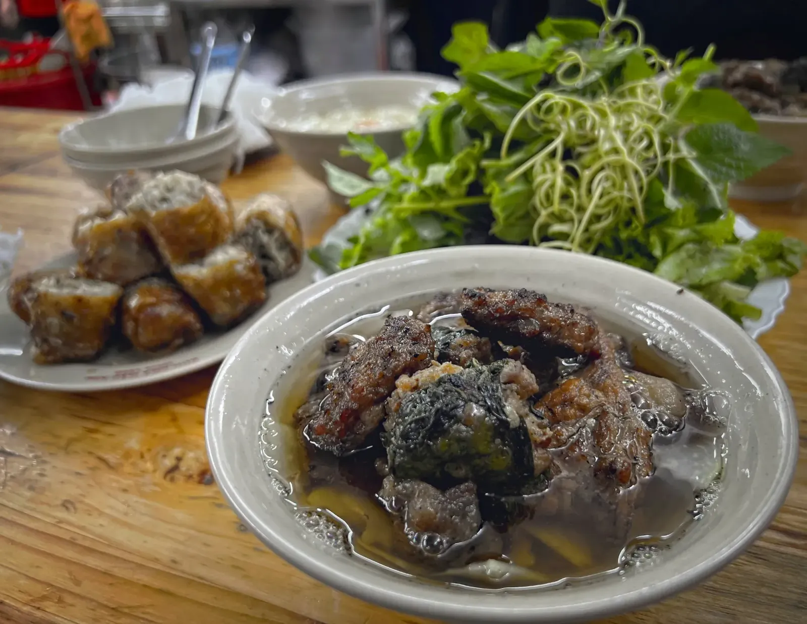 Bún chả by Mr. Wanderer Bowl of Bún chả with herbs and nem cua bể in the background.