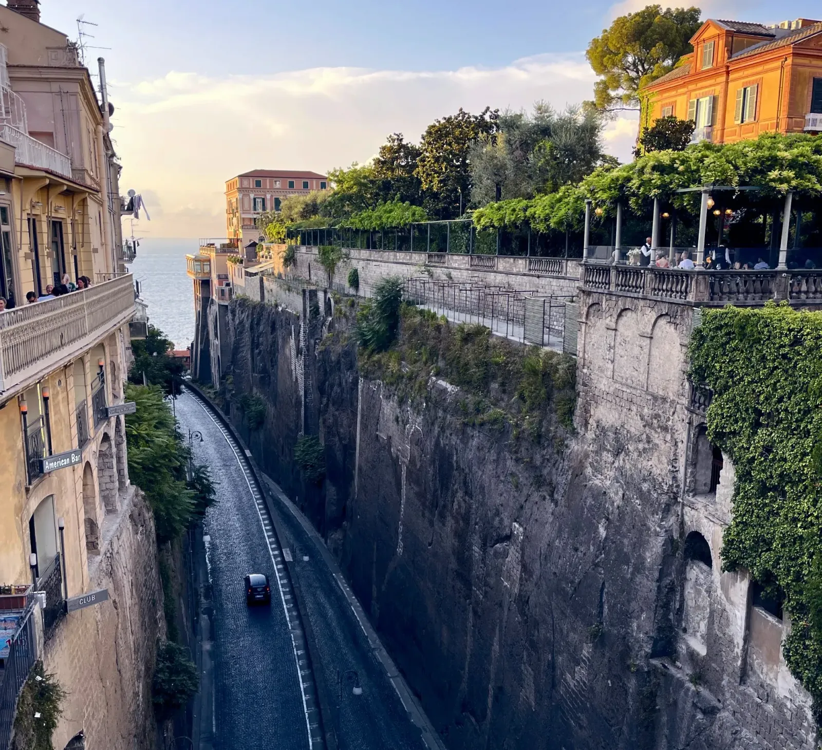 Sorrento by Mr. Wanderer An road in between two tall rock walls leading to the sea.