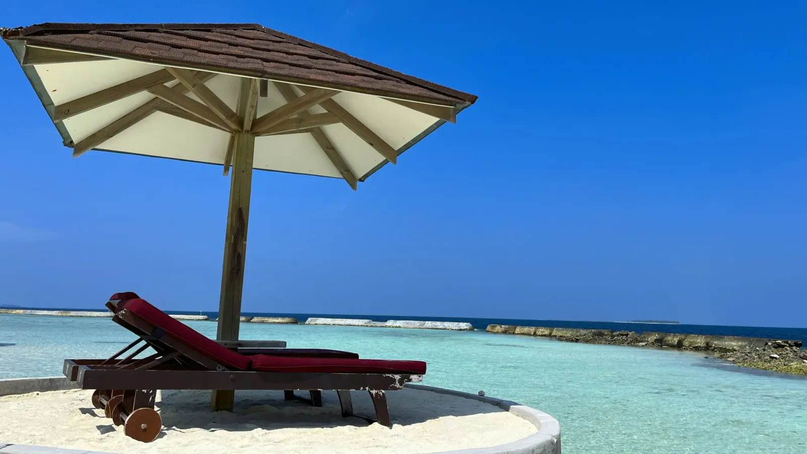 Island Respit by Mrs. Wanderer Two beach chairs under an umbrella overlooking the turquise water