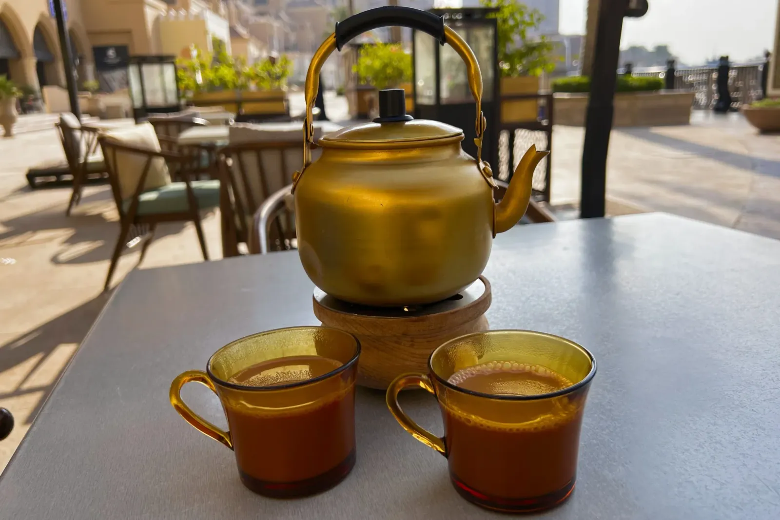 Karak Tea by Mr. Wanderer Gold teapot with two cups filled with karak tea
