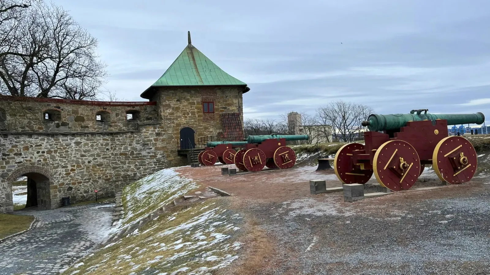 Akershus Fortress by Mrs. Wanderer Red and green canons overlooking the stone fortress wall