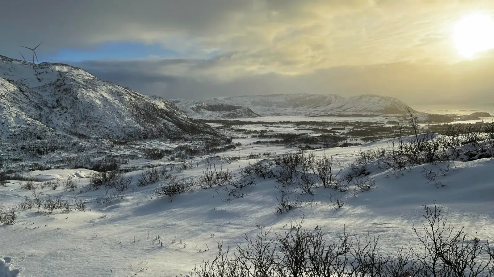 Norwegian Coast by Mrs. Wanderer Sun shining over snow covered hills with windmills in the background