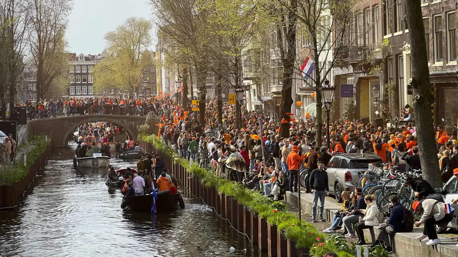 King's Day by Mr.Wanderer Masses of people dressed in orange celebrating King's Day along the canal