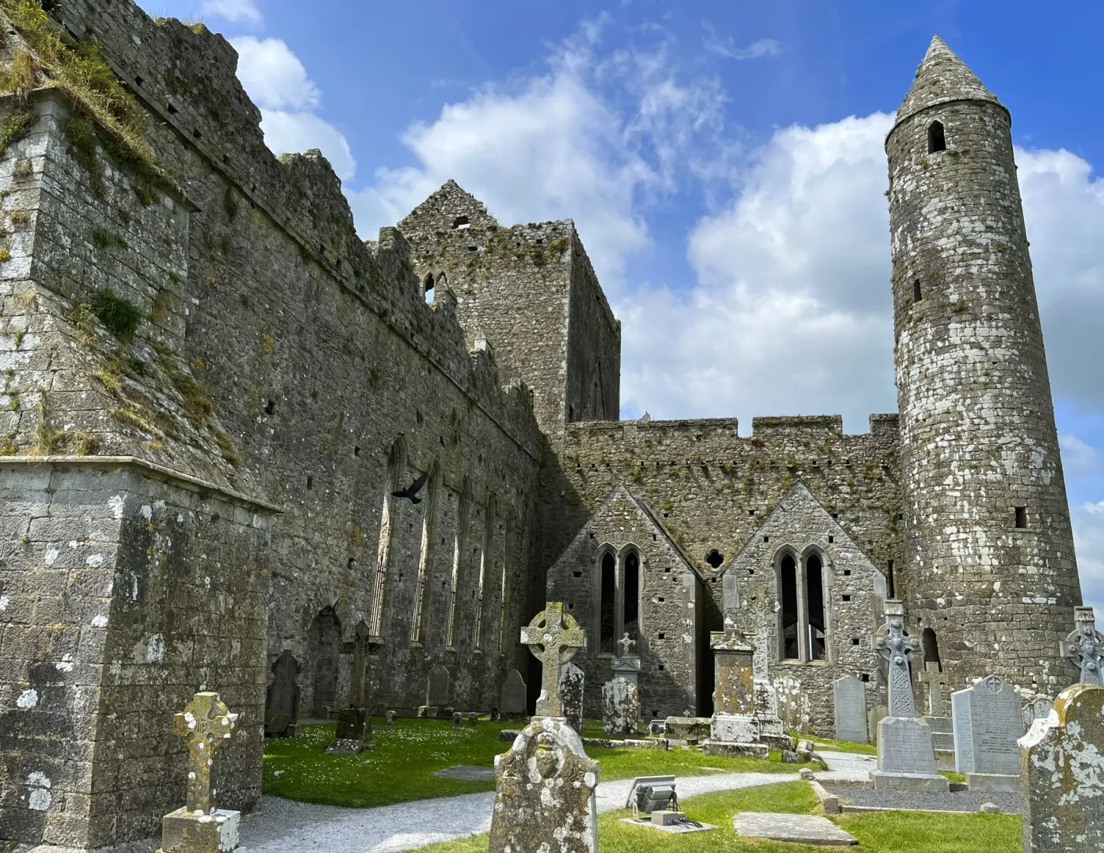 Rock of Cashel Cemetery by Mrs.Wanderer Grey stone towers with aged gravestones