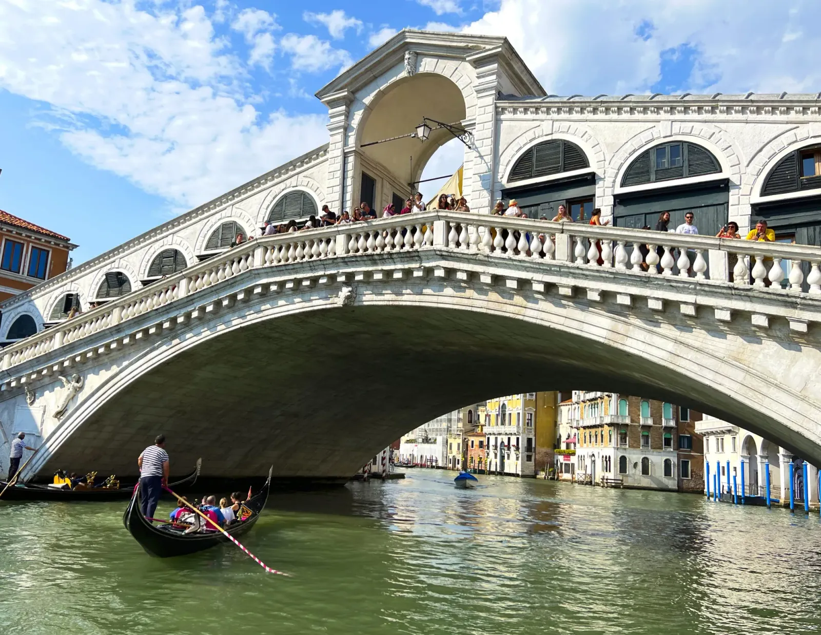 Rialto Bridge by Mr. Wanderer White arched bridge with a gondola passing under it