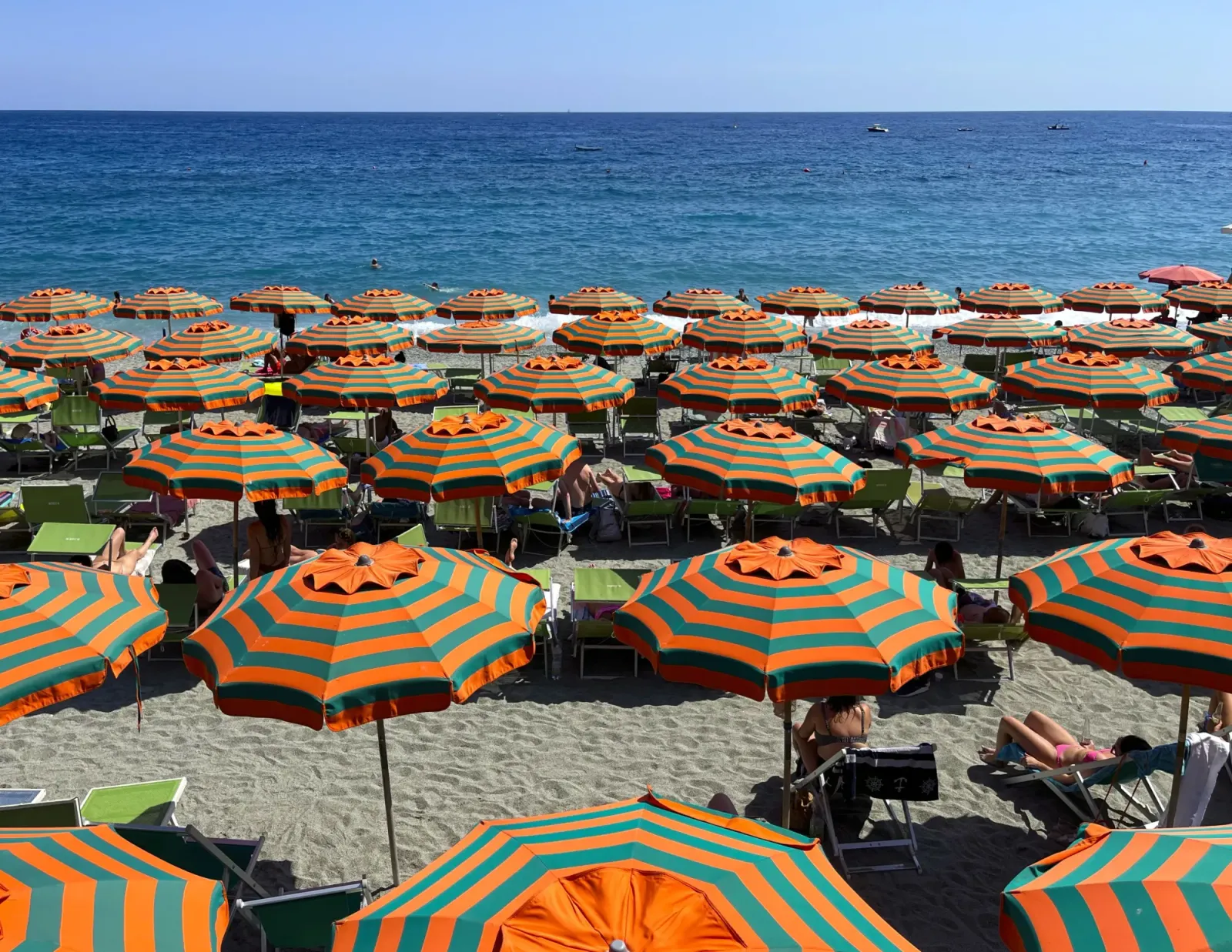 Monterosso Umbrellas by Mrs. Wanderer Orange and Green striped umbrellas on the beach