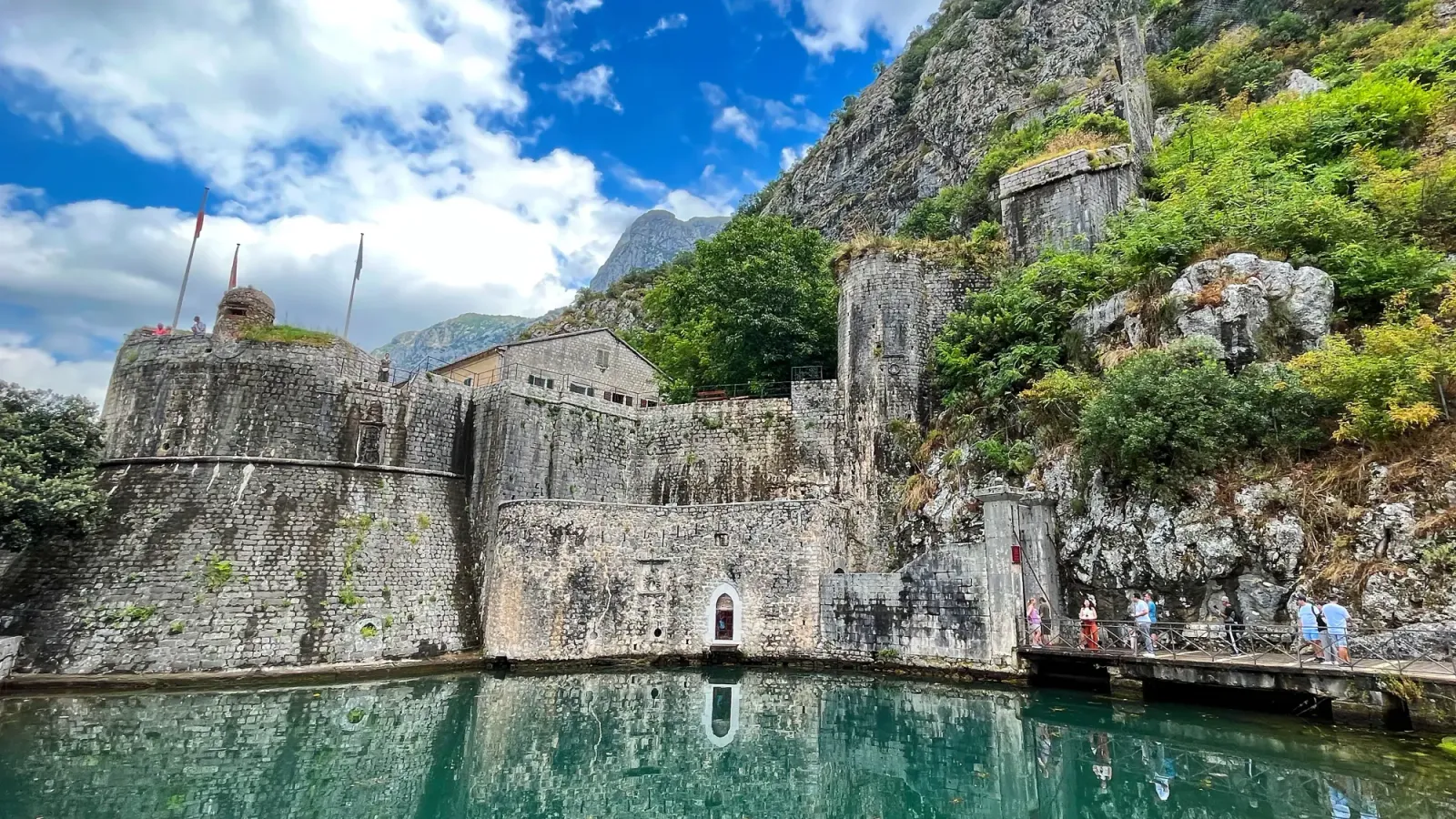 Kotor Fortress by Mrs. Wanderer Grey stone gate with reflective moat
