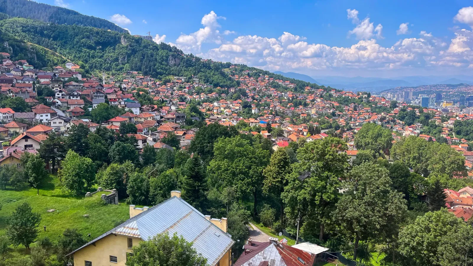 Sarajevo by Cable Car by Mrs. Wanderer Red roofed homes nestled into the hillside interspersed with trees