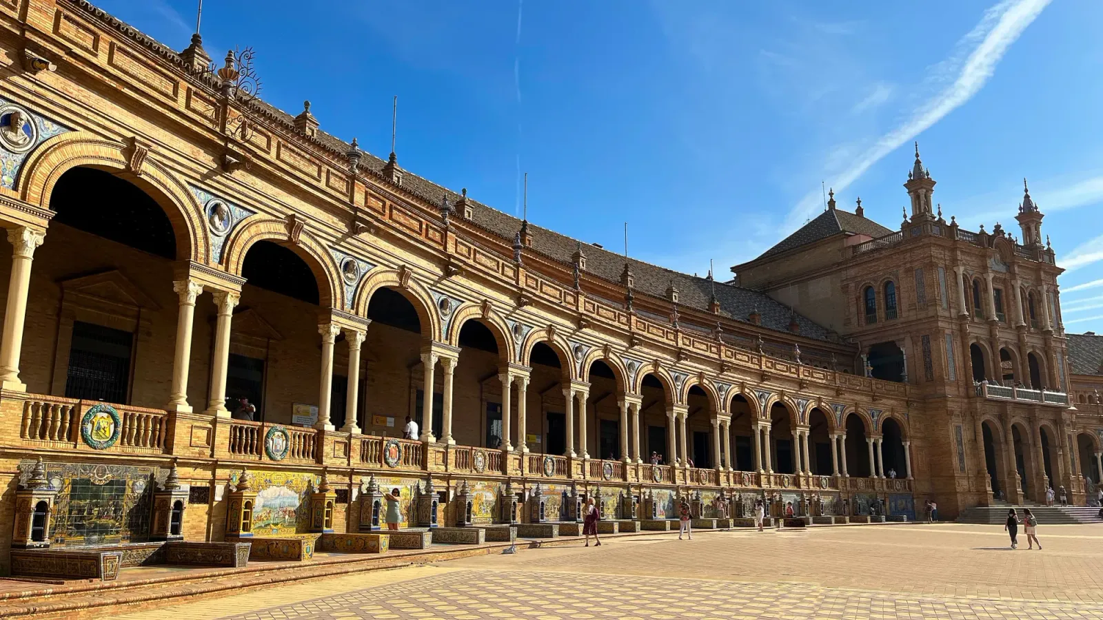 Plaza de España by Mrs. Wanderer Series of arches with a central building covered in tiling