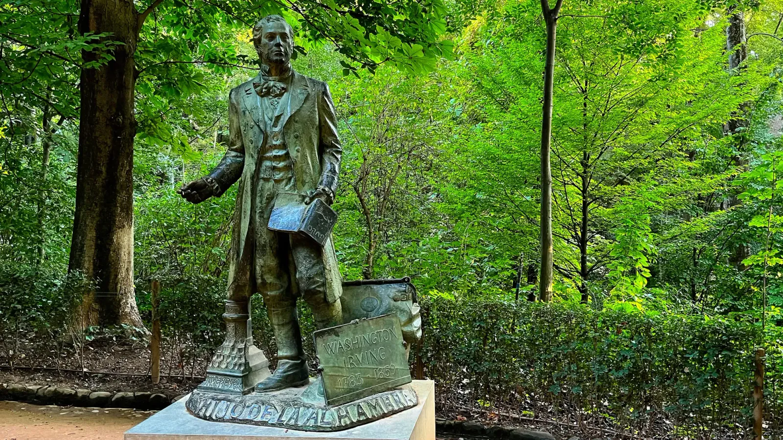 Washington Irving Statue by Mrs. Wanderer Green statue of Washinton Irving in front of trees