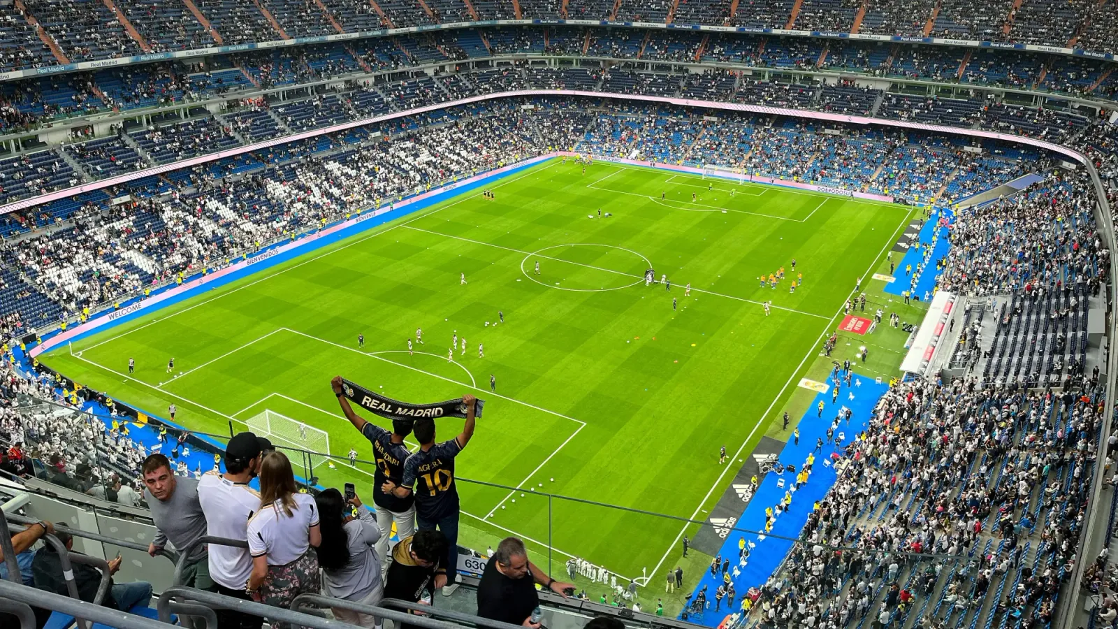 Santiago Bernabéu Stadium by Mrs. Wanderer Soccer stadium with fans holding up a soccer scarf
