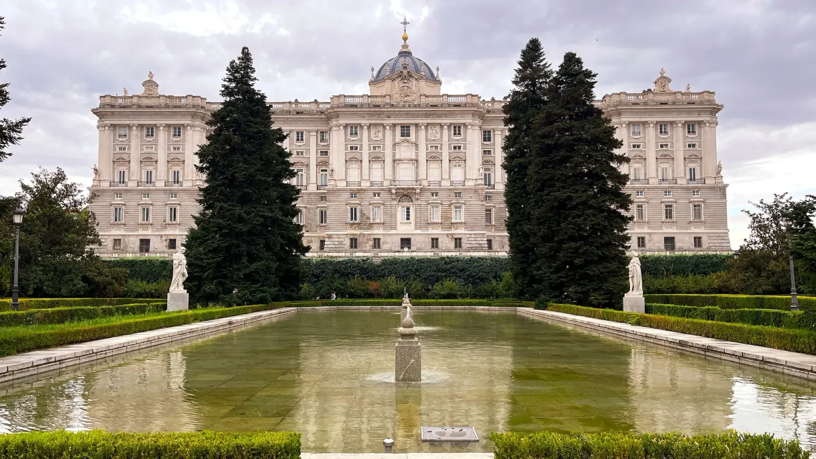 Royal Palace of Madrid by Mr. Wanderer White palace overlooking a reflecting pool with tall trees on either side