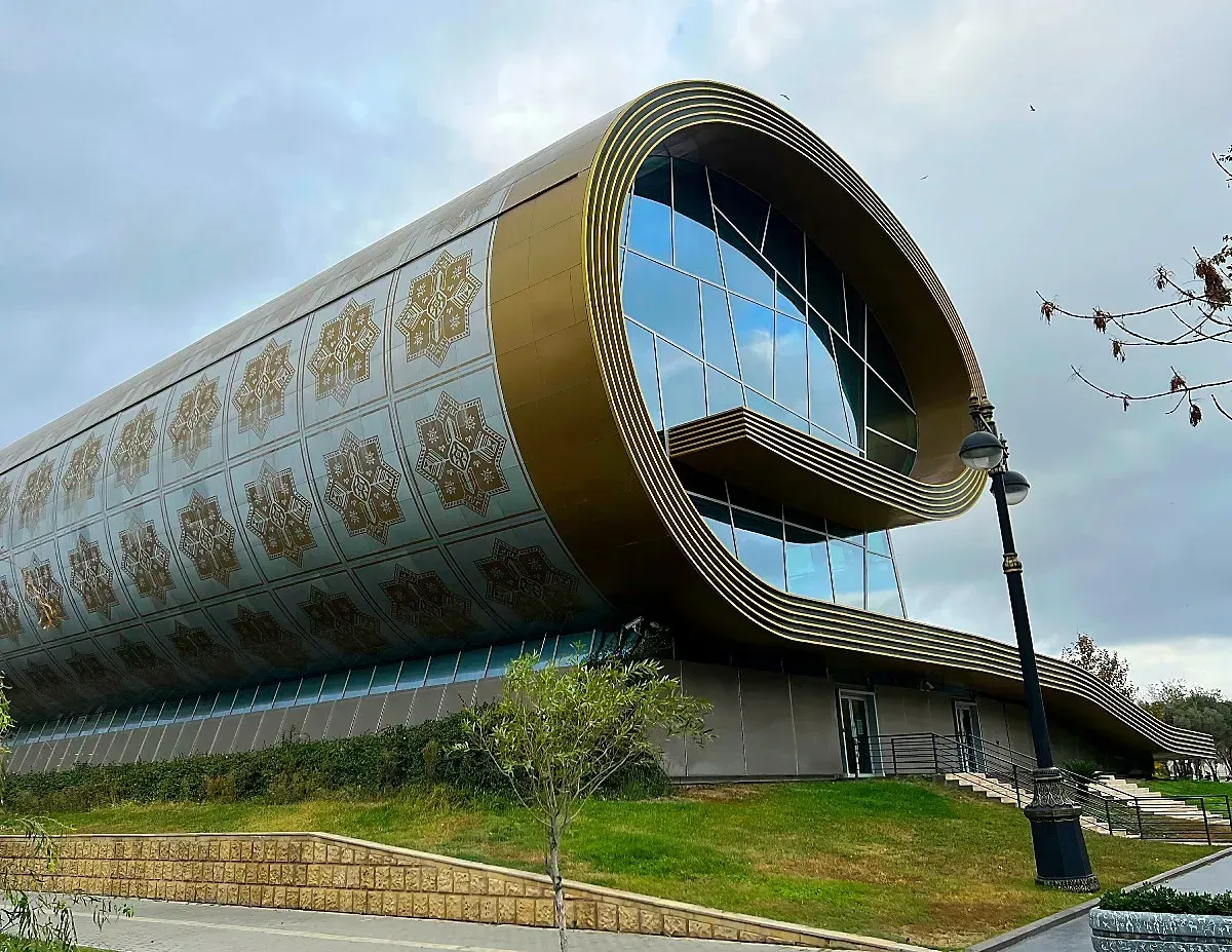 Azerbaijan National Carpet Museum by Mrs. Wanderer Glass building in the shape of a partially rolled carpet