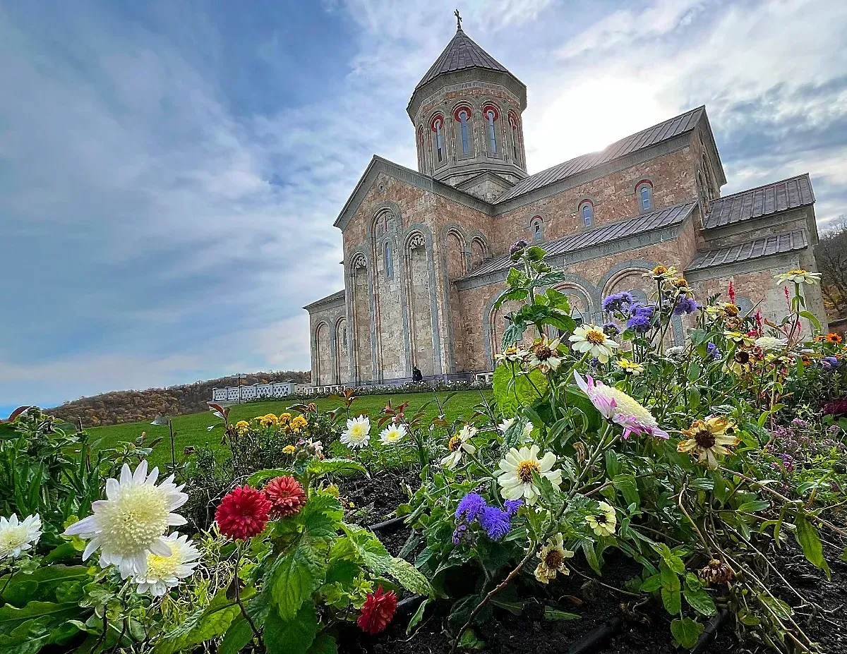 Bodbe Monastery of St. Nino by Mr. Wanderer Flowers obscure the foreground and a stone monastery rests in the background