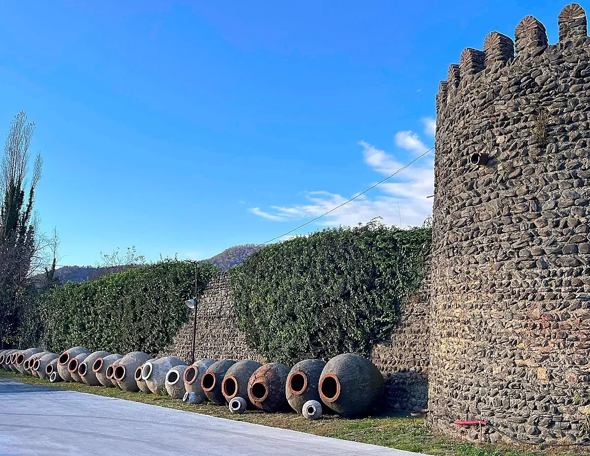 Industrial Qvevri by Mr. Wanderer A stone wall lined with giant clay jugs that used to house wine