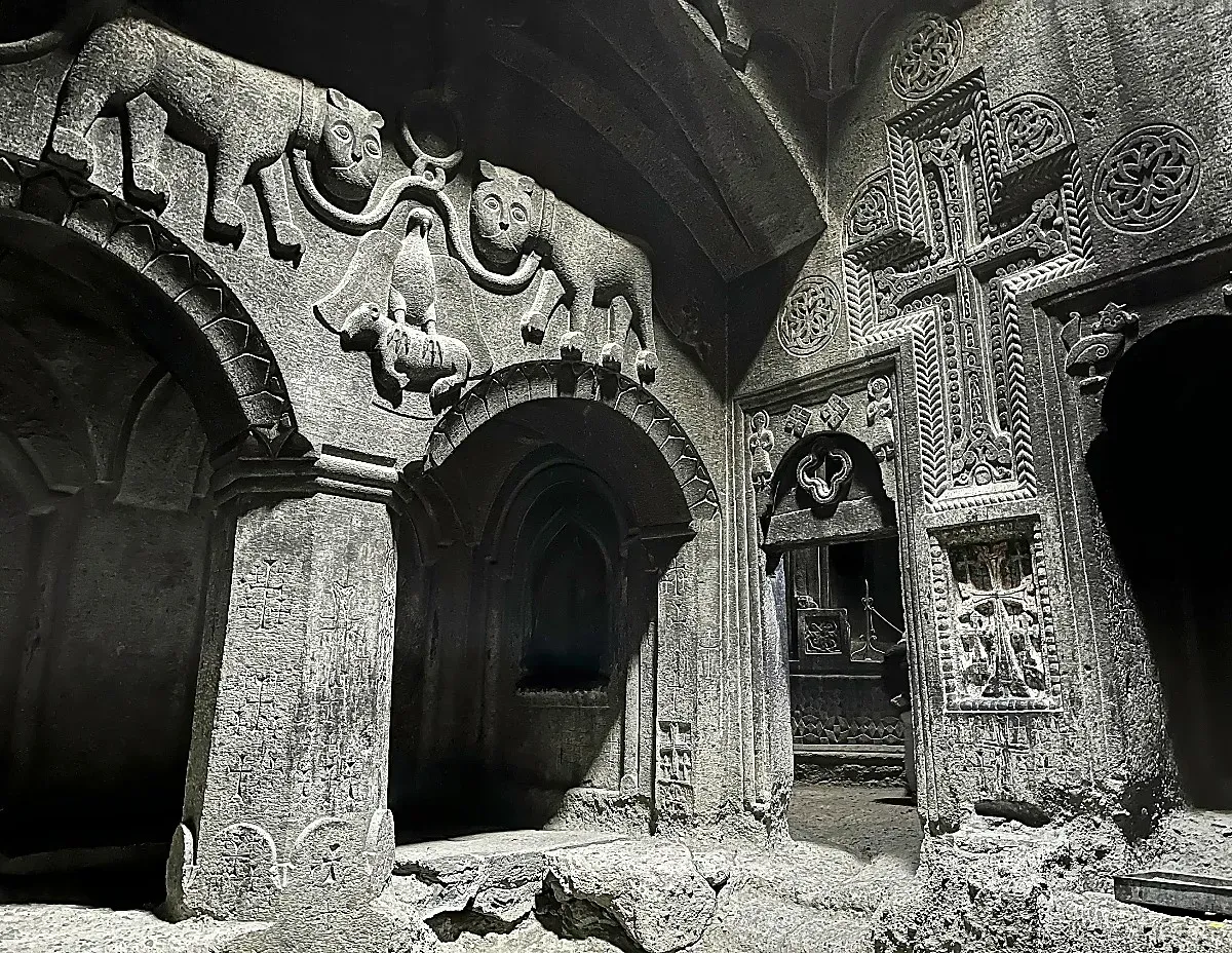 Geghard Carvings by Mrs. Wanderer Grey stone walls carved with animals and crosses over archways
