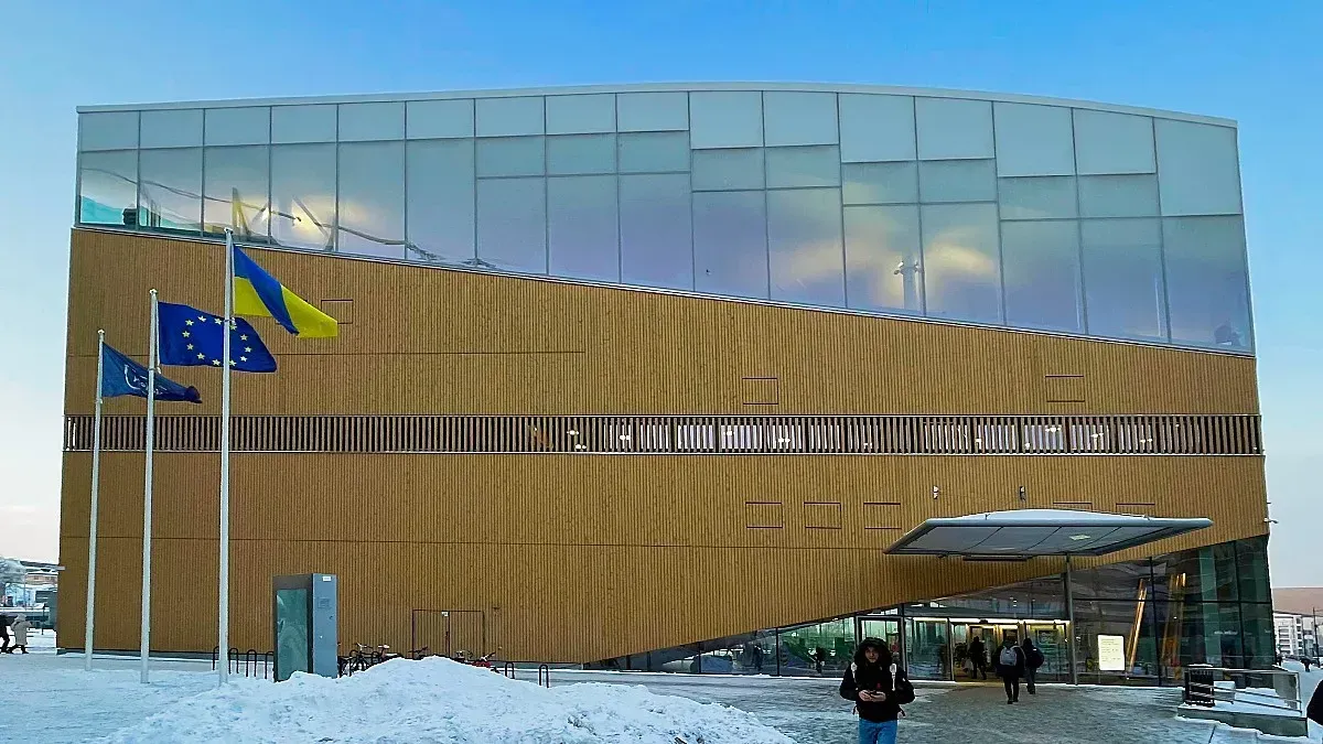 Helsinki Central Library Oodi by Mrs. Wanderer Wooden building with glass windows covering the upper third