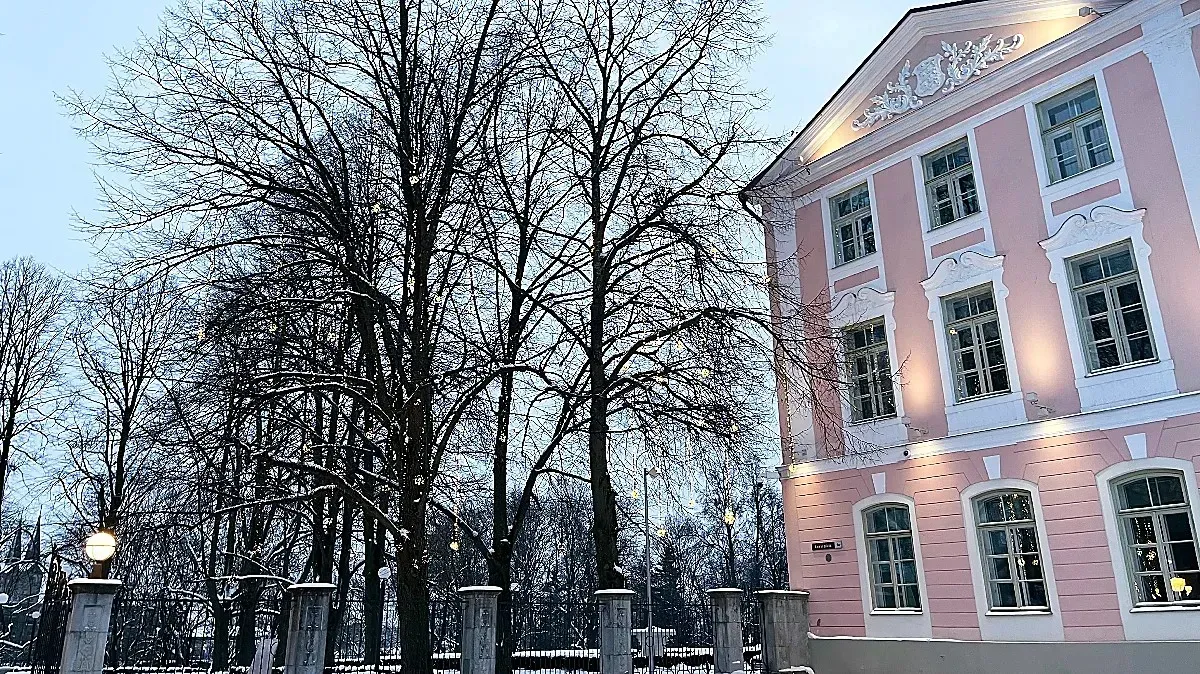 Estonian Parliament by Mrs. Wanderer Pink building with white trimming next to a wintry garden