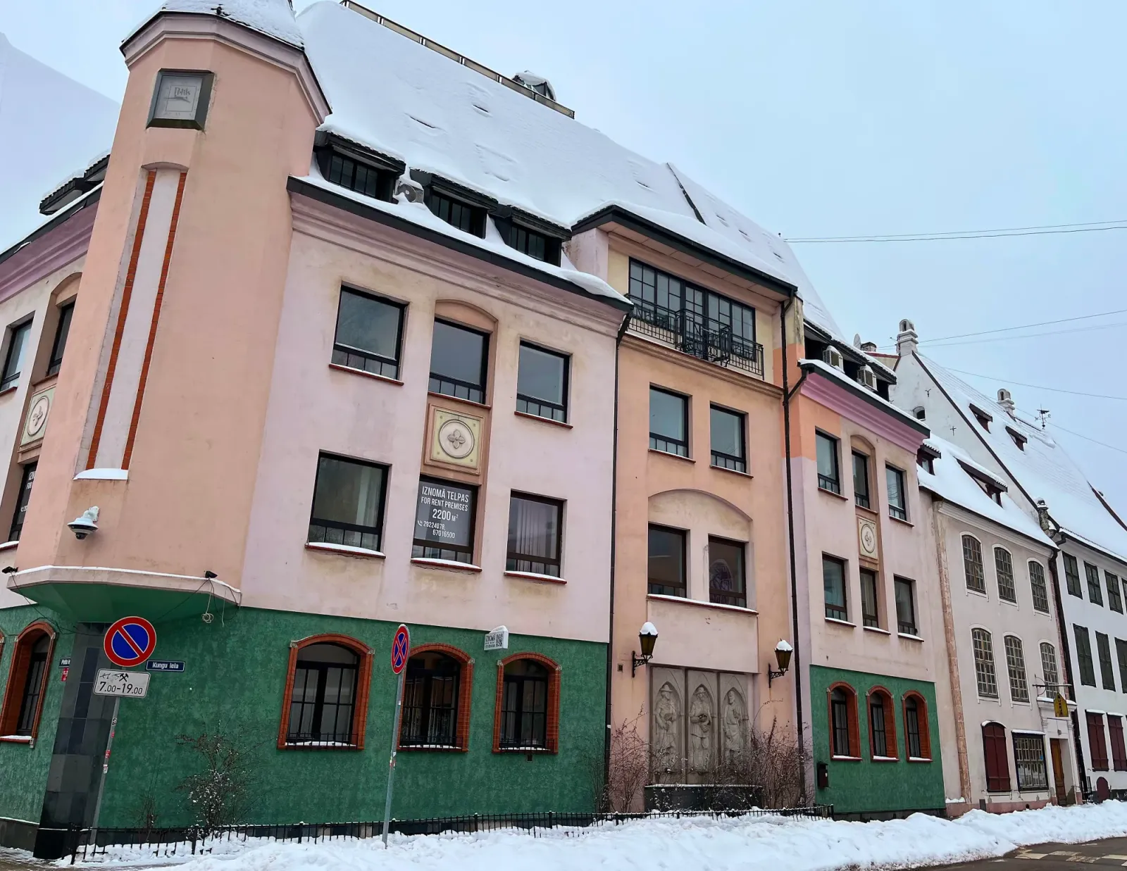 Latvian Streets by Mr. Wanderer Pink and green buildings on a snow covered street
