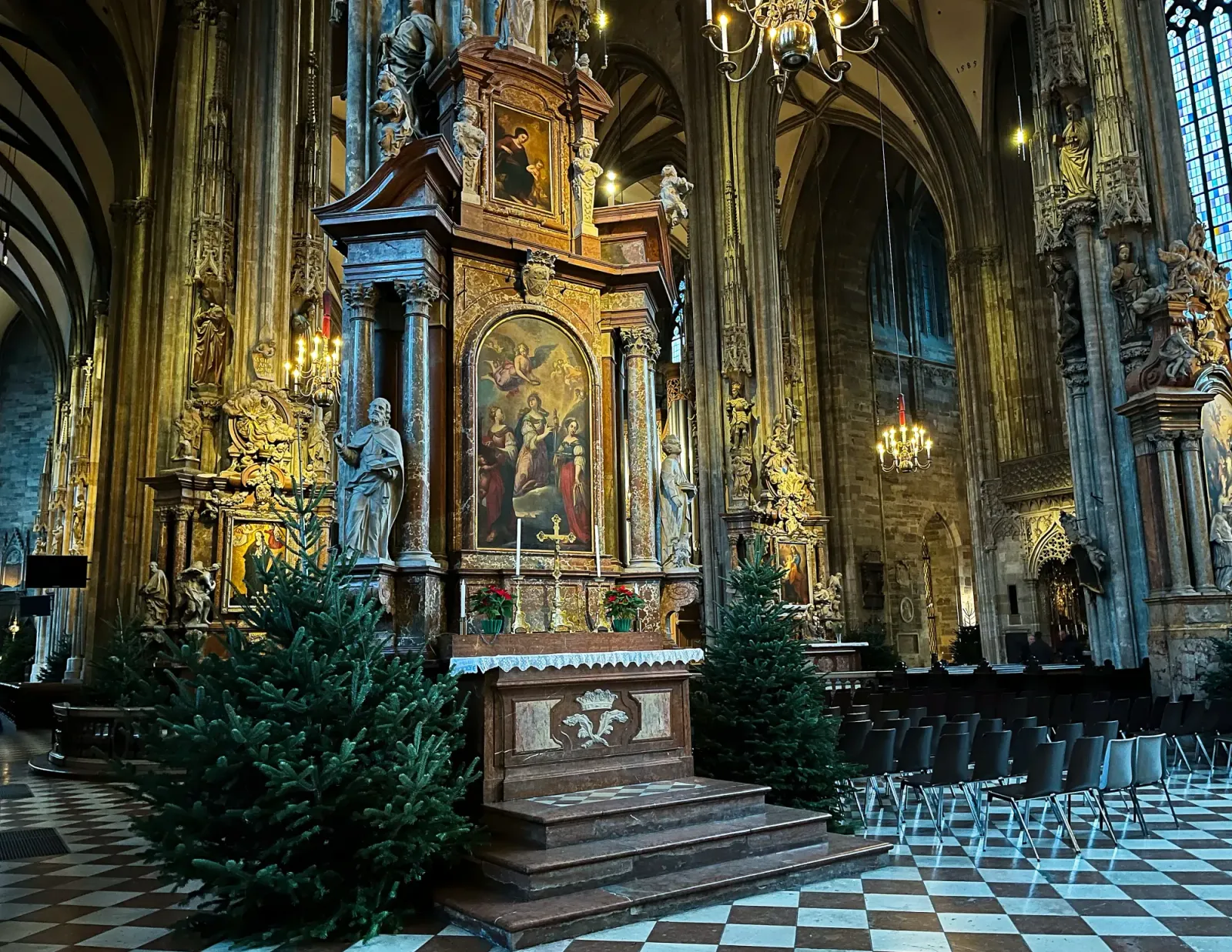 St. Stephen's Cathedral by Mrs. Wanderer Inside of the church with black and white tiled floors, christmas trees for decoration, and ornately decorated columns