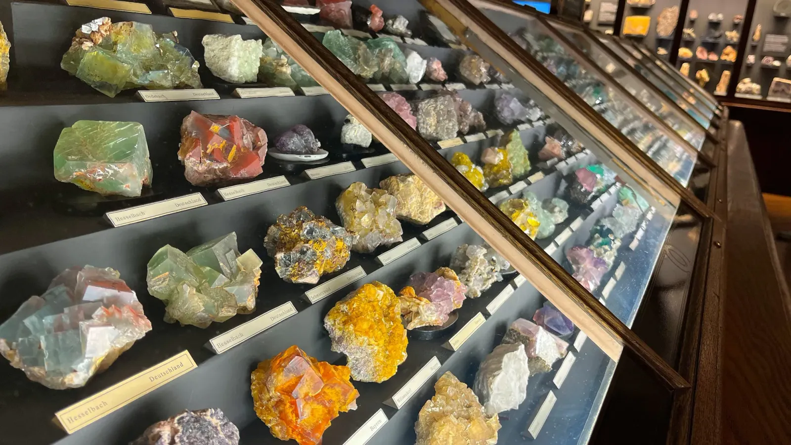 Geodes by Mrs. Wanderer Different colored stones in a slanted cabinet