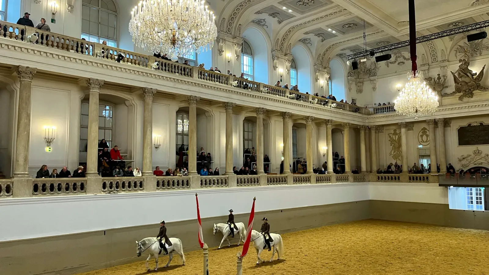 Spanish Riding School by Mrs. Wanderer White columned seating with horses being ridden in the middle