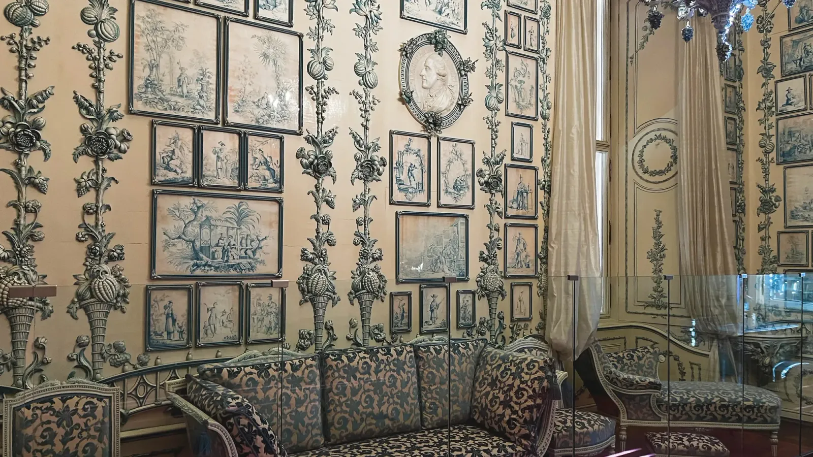 Schönbrunn Palace Decor by Mrs. Wanderer A cream colored room with blue paintings and blue floral couch