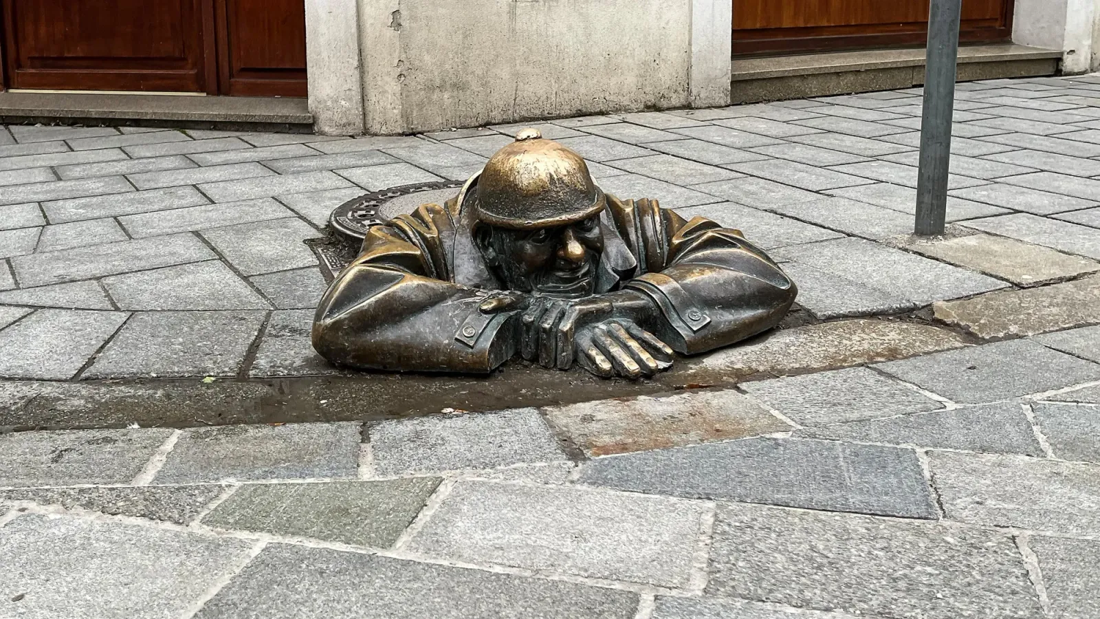 Čumil Statue by Mrs. Wanderer Bronze sewer worker statue popping its head out of a manhole