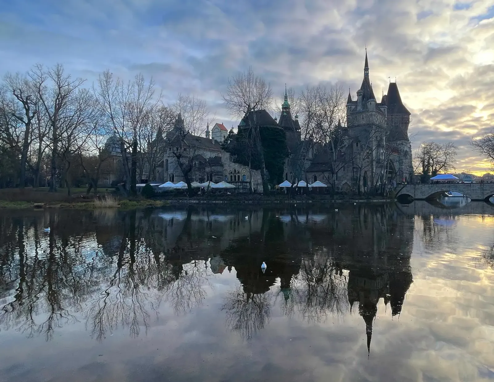 Vajdahunyad Castle Reflection by Mrs. Wanderer Grey stone castle and dusky clouds reflected in a mirror-like lake