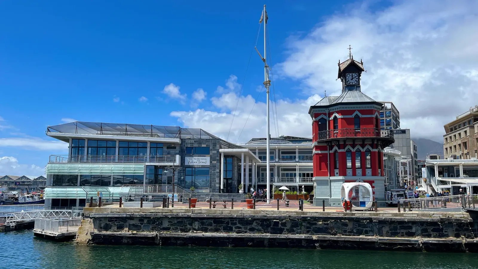 Victoria Wharf by Mr. Wanderer Glass buildings with a red tower on the water