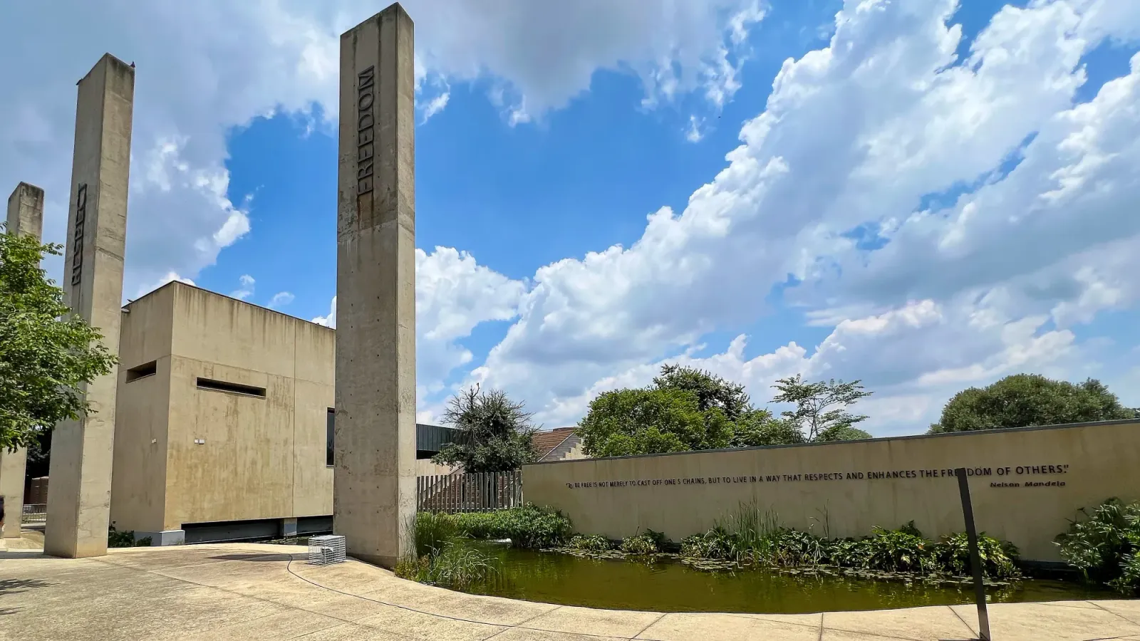 Apartheid Museum by Mrs. Wanderer Concrete facade to the museum with pillars stating "Freedom" and "Respect"
