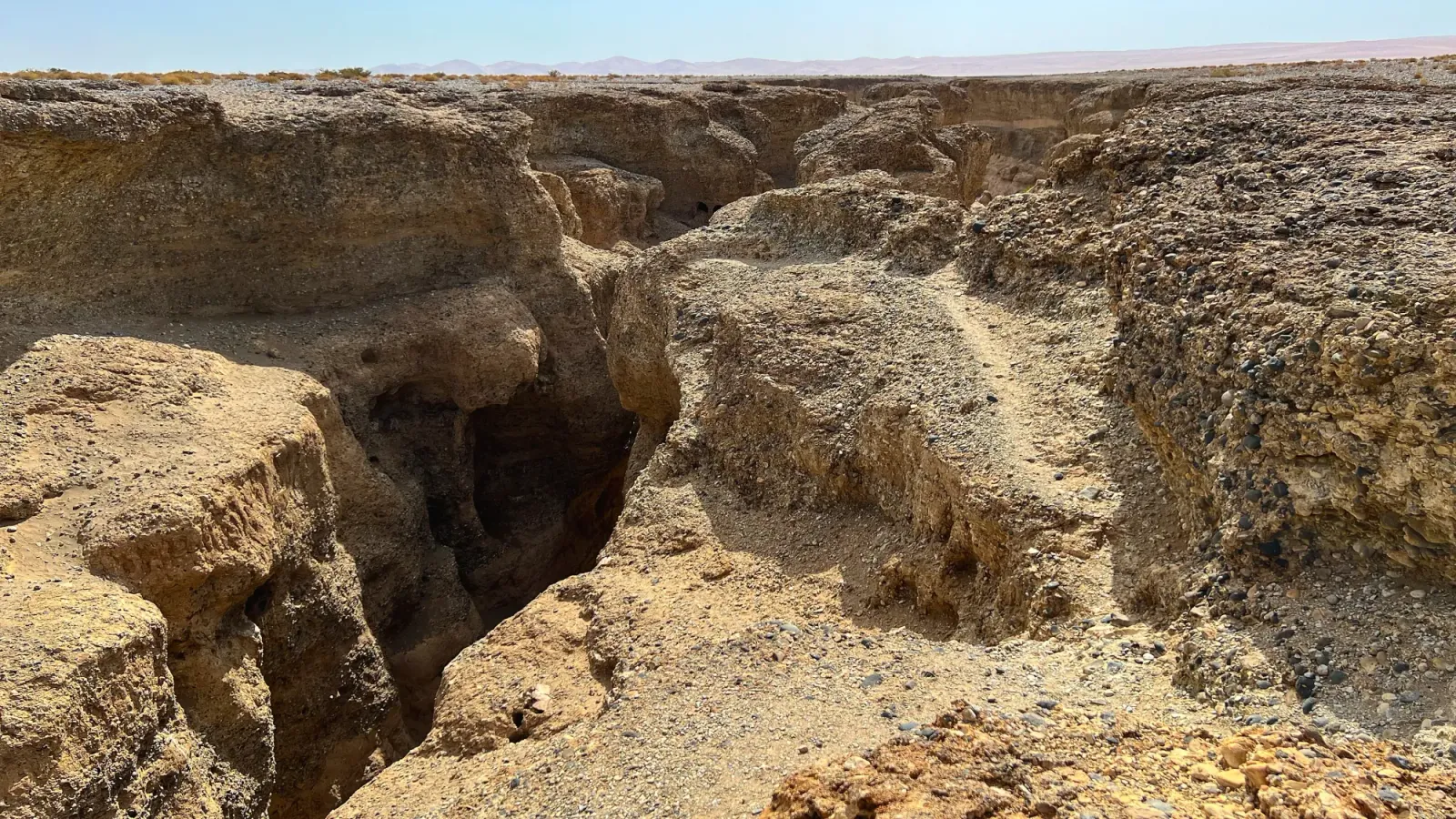 Rocky crevasse dropping out of the otherwise flat land