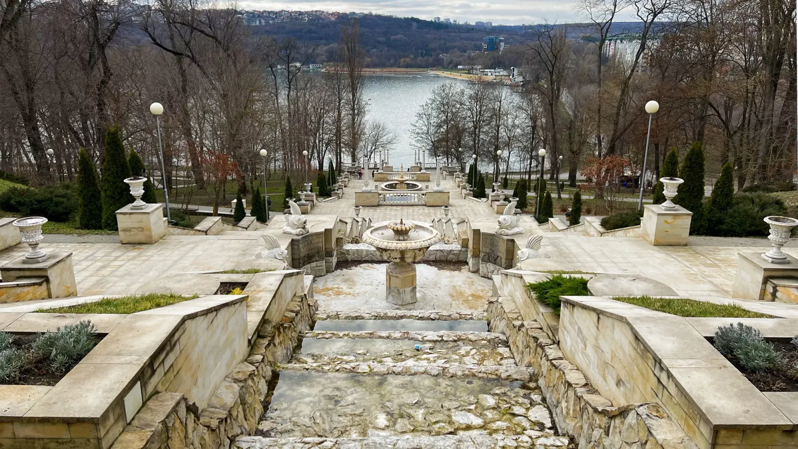 Scara Cascadelor by Mr. Wanderer Stone stairwell photographed from above overlooking a lake