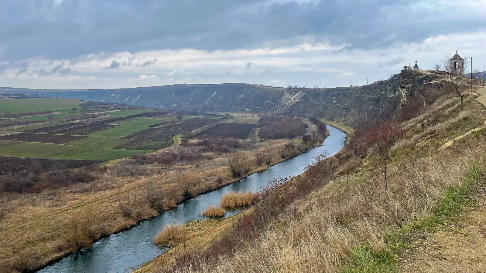 Old Orhei by Mr. Wanderer Viewpoint overlooking a sloping valley with a river running through it
