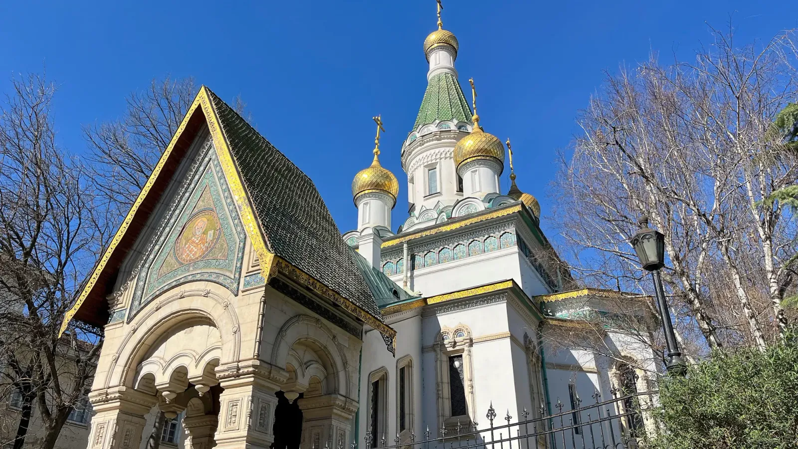 Sofia Church by Mr. Wanderer Pointy white church with green and gold shingles and detailing