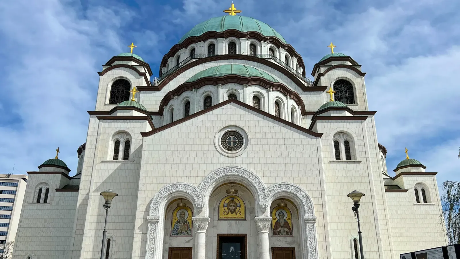 Temple of Saint Sava Facade by Mrs. Wanderer White stone facade with green roof and small golden mosaic details