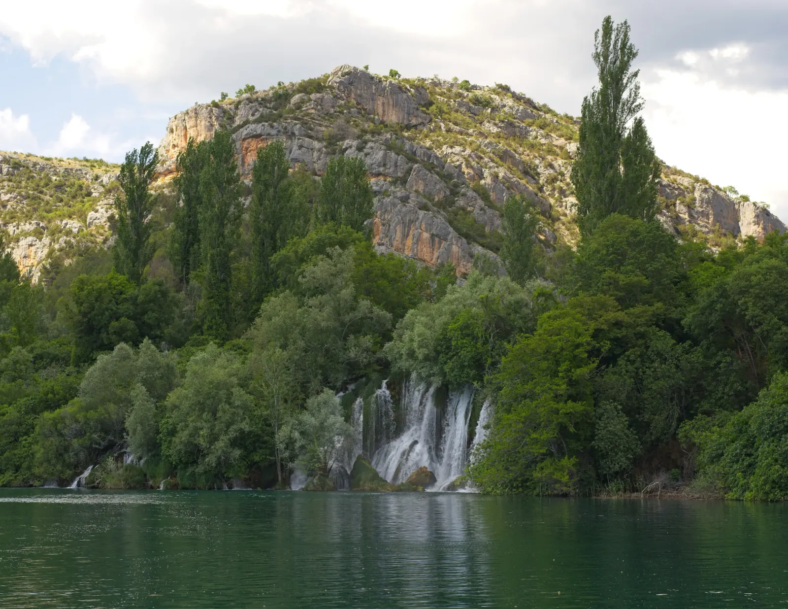 Roški Slap by Mr. Wanderer Waterfall with a mountain set behind it