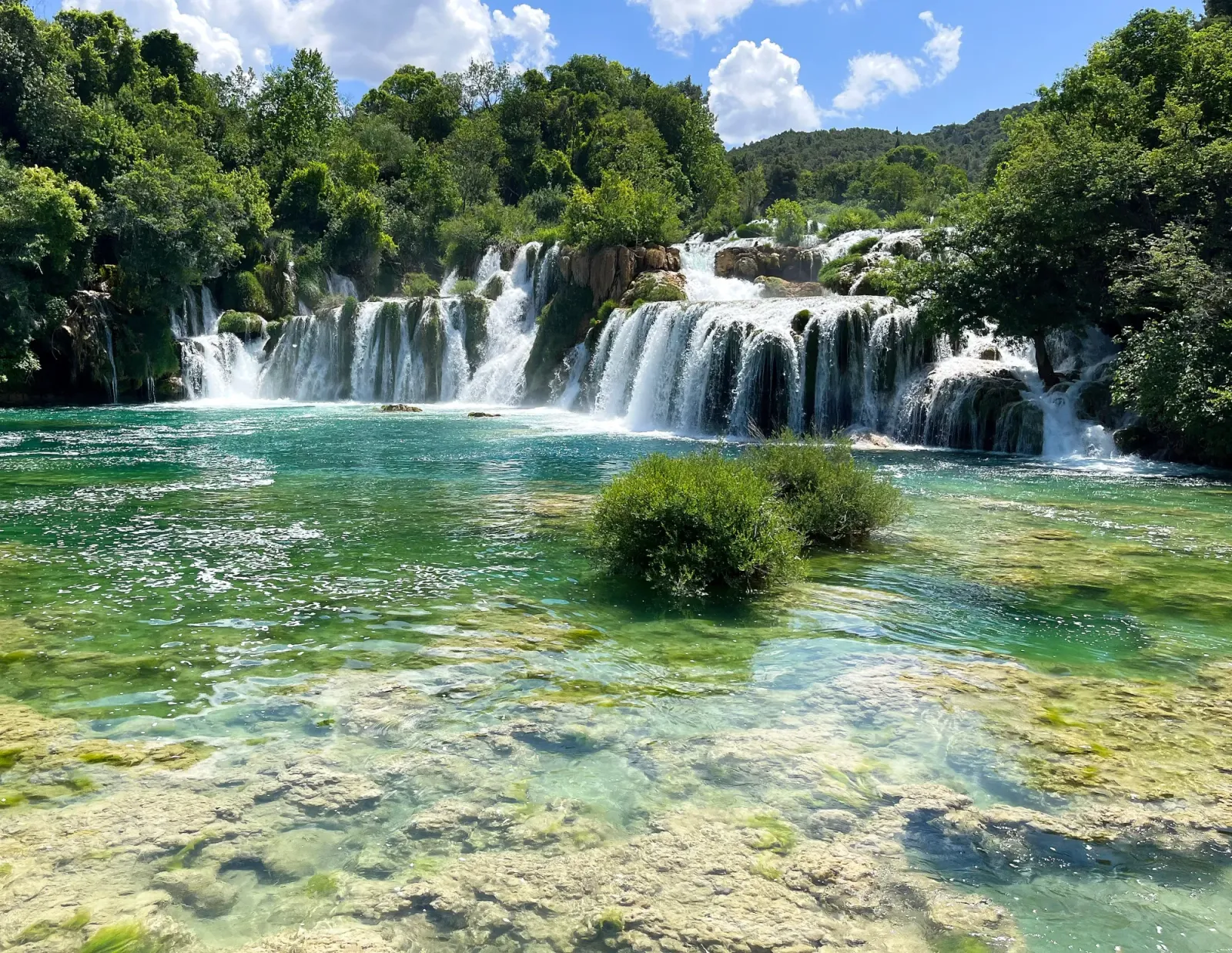 Skradinski Buk by Mrs. Wanderer Cascading travertine surrounded by lush trees into green water
