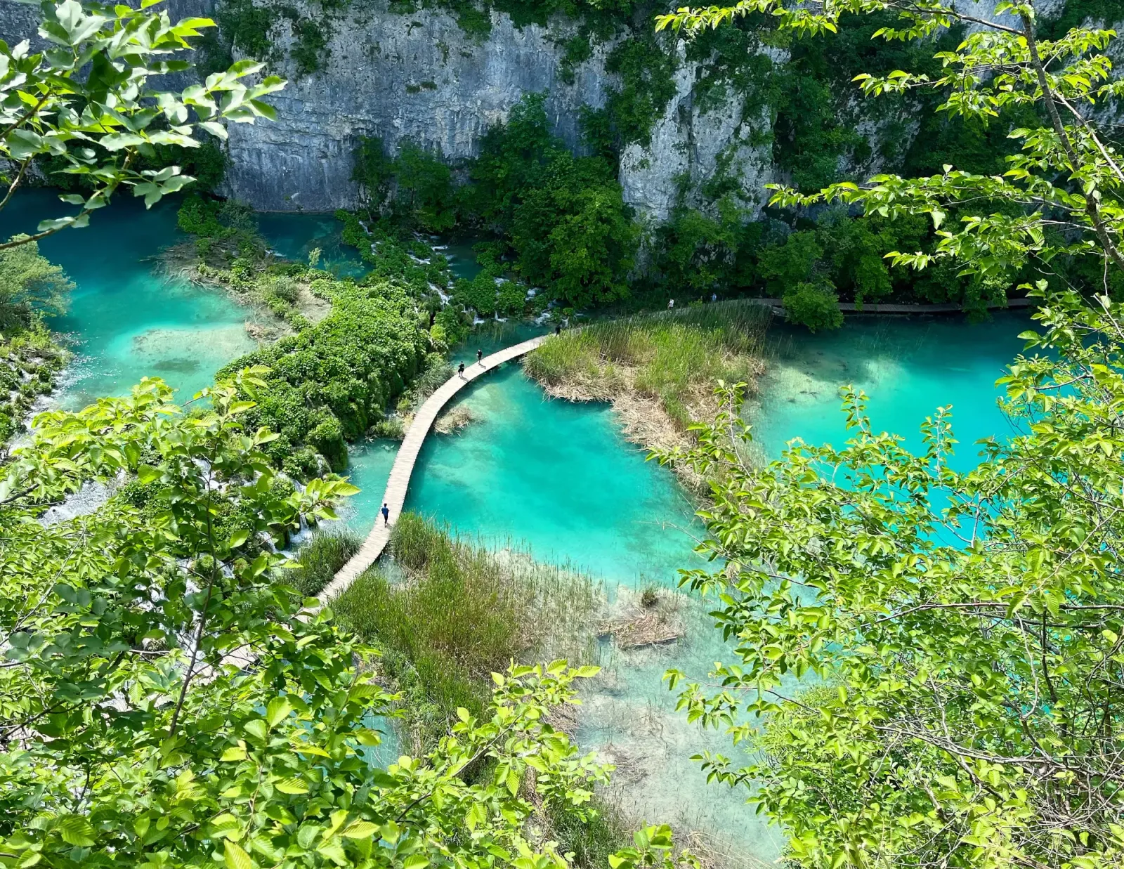Plitvice Pathways by Mrs. Wanderer "S"-shaped walking pathway over aqua water surrounded by lush green and viewed from above