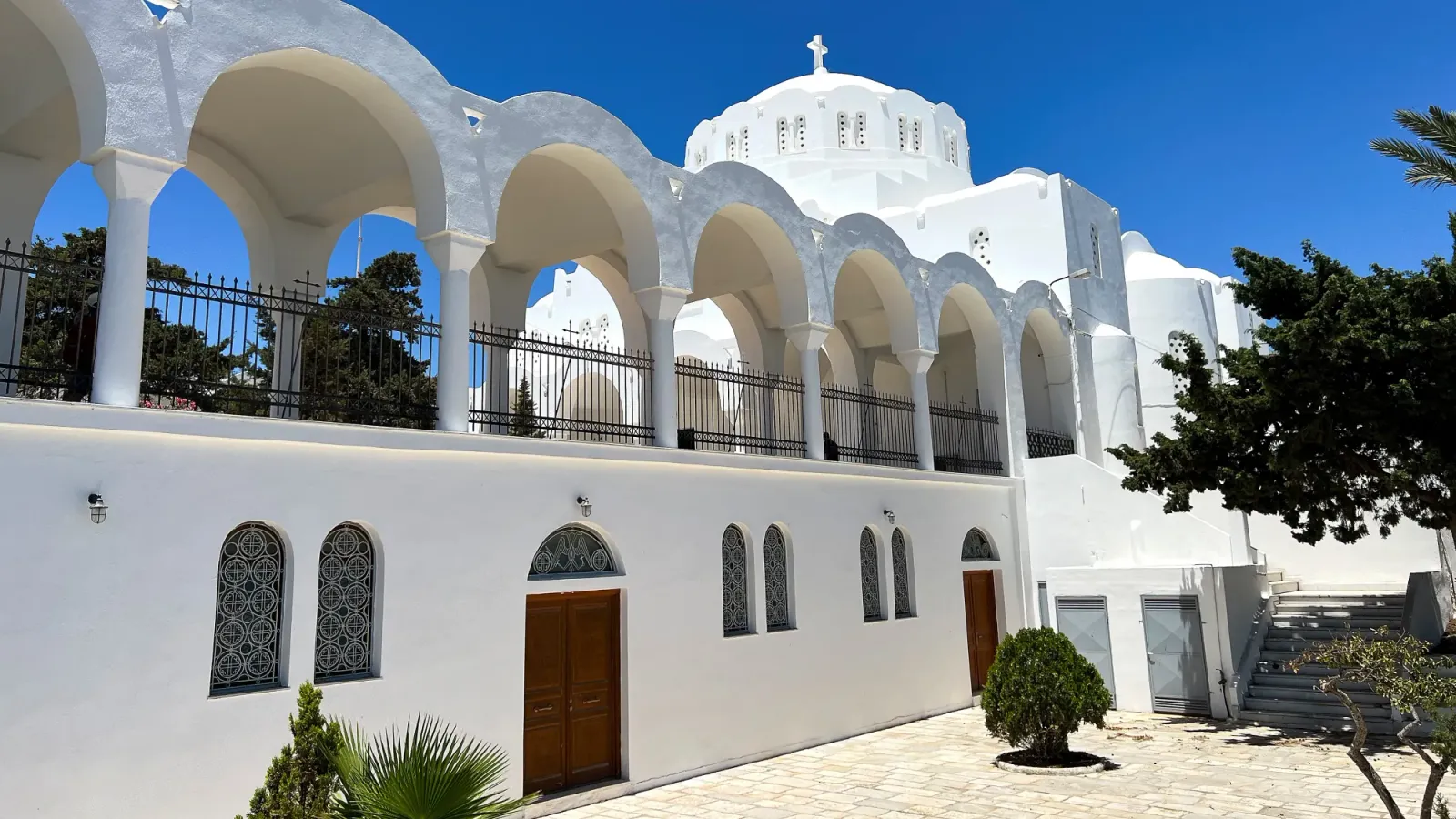 Metropolitan Church of Ypapanti Thira by Mr. Wanderer White washed building with a series of arches set before a domed roof