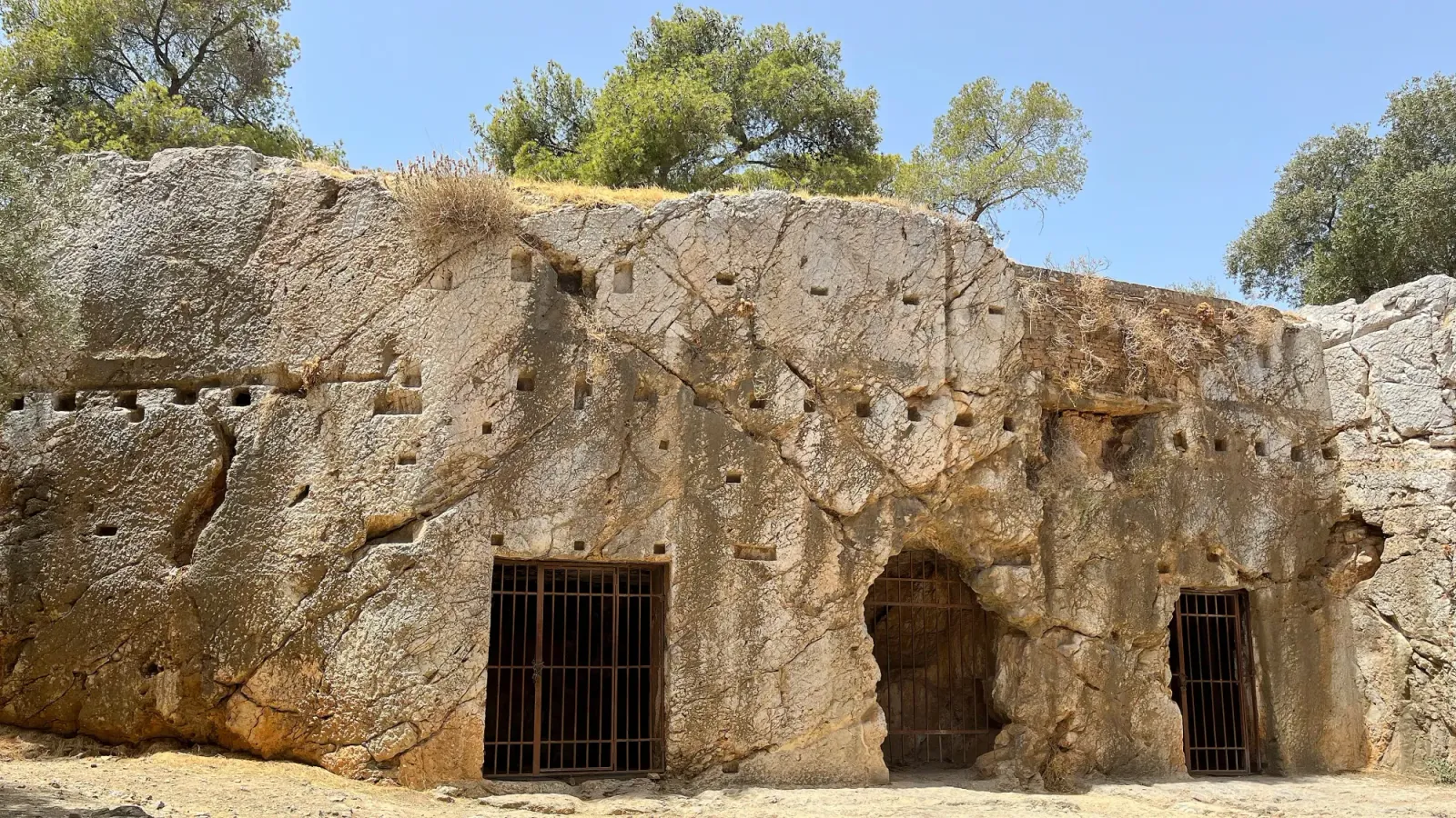 Prison of Socrates by Mr. Wanderer Stone wall with multiple indents with three metal grates in tact